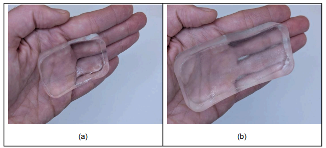 A hydrogel coupling pad being held in a hand, showing the soft, transparent, deformable material shaped to fit the transducer faces.